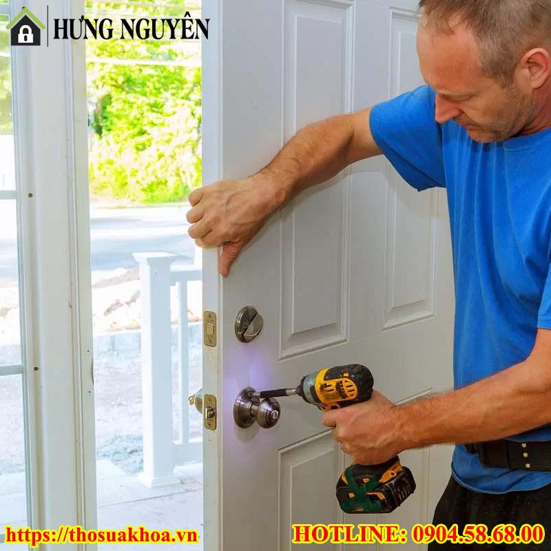Thợ đang lắp khóa cửa tại nhà cho khách